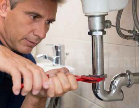 plumber assessing burst pipe in a Longmont, CO basement during winter freeze